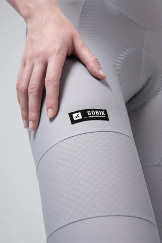 Dettaglio gamba salopette ciclismo donna Gobik Absolute 7.0 con tessuto compressivo tecnico, grip stabile e logo Gobik per ciclismo su strada ad alte prestazioni