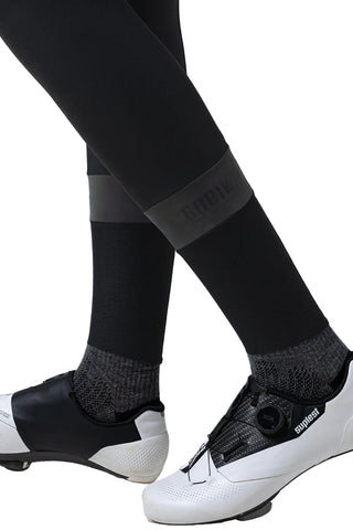 Dettaglio fondo gamba pantaloni ciclismo Gobik Absolute 7.0 Women con inserti riflettenti per visibilità su strada.