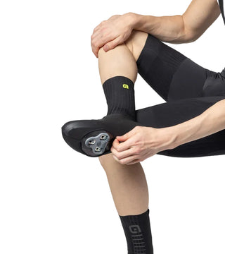 Copriscarpe ciclismo invernali Alé Whizzy Winter – vista indossata mentre il ciclista regola la protezione sulla tacchetta, copriscarpe impermeabili per bici da strada