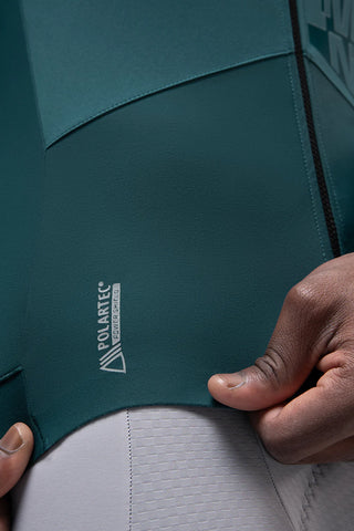 Dettaglio logo Polartec Power Shield su giacca Gobik Element Sunken verde petrolio, materiale antivento e idrorepellente per ciclisti professionisti.