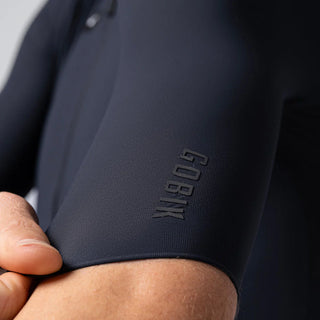 Dettaglio manica maglia ciclismo uomo Gobik blu scuro – logo stampato in rilievo e tessuto tecnico elasticizzato a compressione graduata.