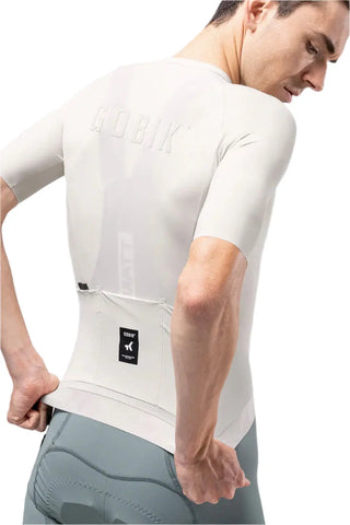 Dettaglio retro maglia Gobik CX Solid Argonite bianca su uomo, logo in rilievo e tasche posteriori per ciclismo.