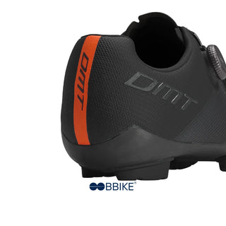 Dettaglio tacco delle scarpe da MTB DMT KM0 EVO nere, con fascia posteriore arancione ad alta visibilità e struttura ergonomica per massimo supporto durante la pedalata.

