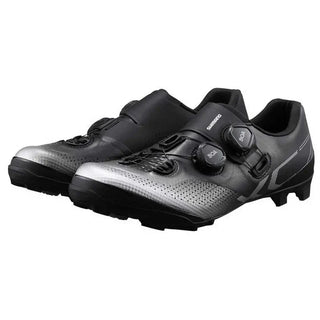 Vista laterale della scarpa Shimano XC7 MTB nero/argento con doppi rotori BOA e design aerodinamico, ideale per mountain bike e gare cross-country ad alta intensità.