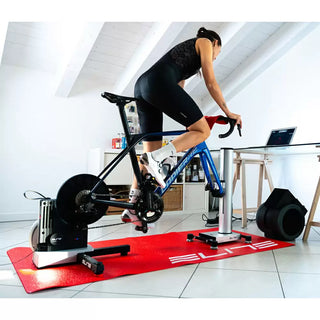 Atleta che utilizza rullo Elite Justo 2 con ventilatore Elite Aria per allenamento indoor professionale su bici da corsa