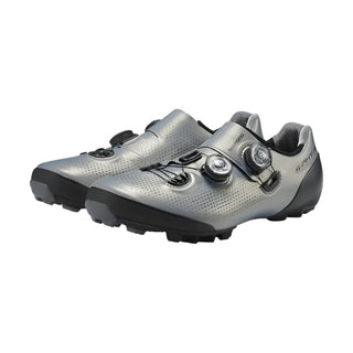 Coppia scarpe Shimano S-Phyre XC902 argento viste diagonalmente da davanti, chiusura BOA doppia e tomaia traforata per massima ventilazione e prestazioni MTB.